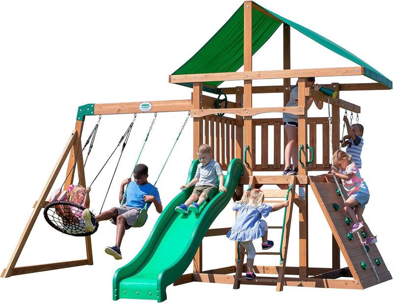 A complete set of wooden mountain-style swings, equipped with a colorful canvas sunshade, a wave slide, a rope swing, a net swing, and a rock wall with climbing ropes and ladders. I4067